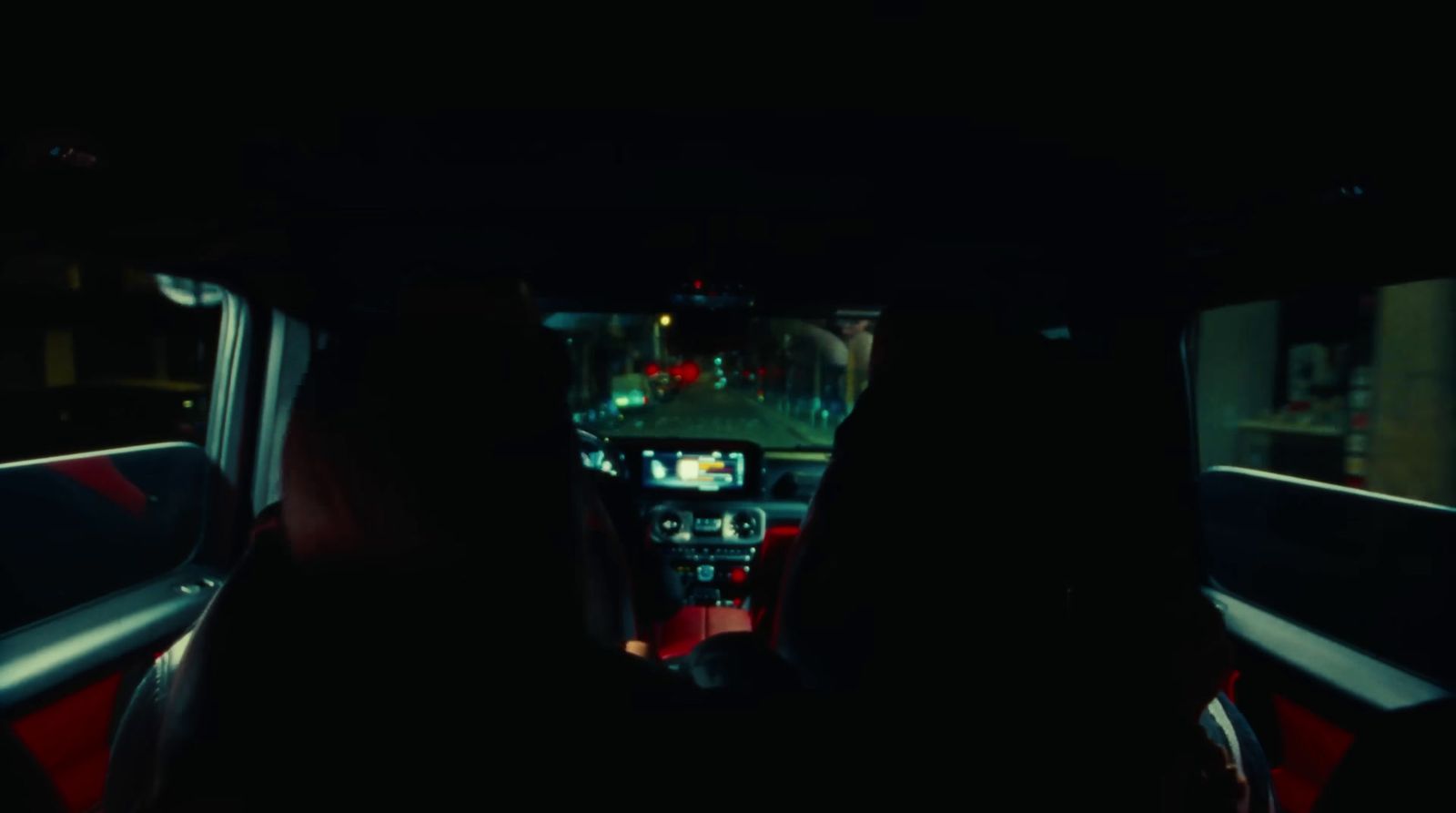 a person sitting in the back seat of a car at night