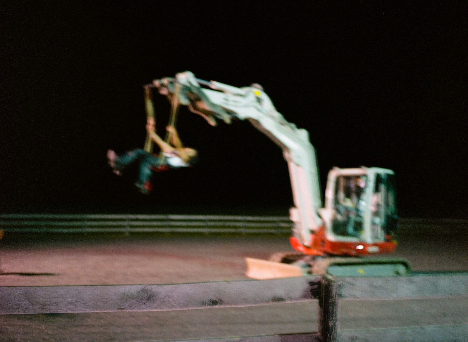 a crane is lifting a man on a skateboard