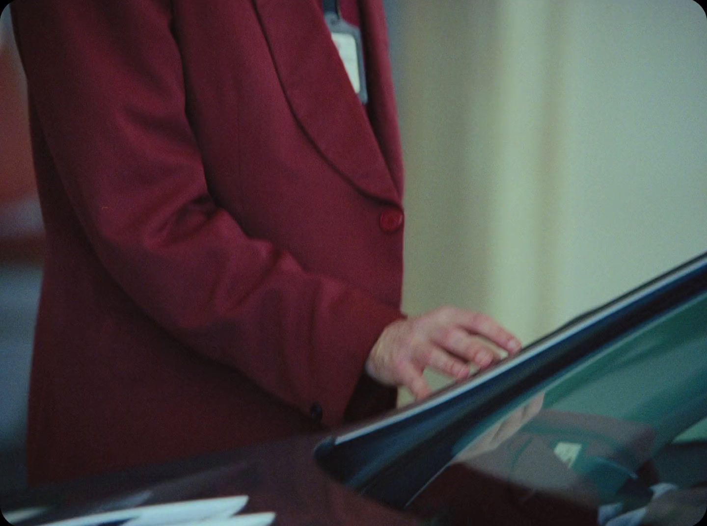 a man in a red suit is looking at a car