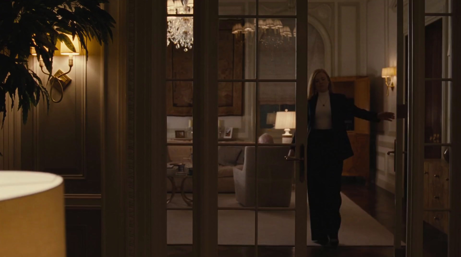 a woman in a suit is entering a room