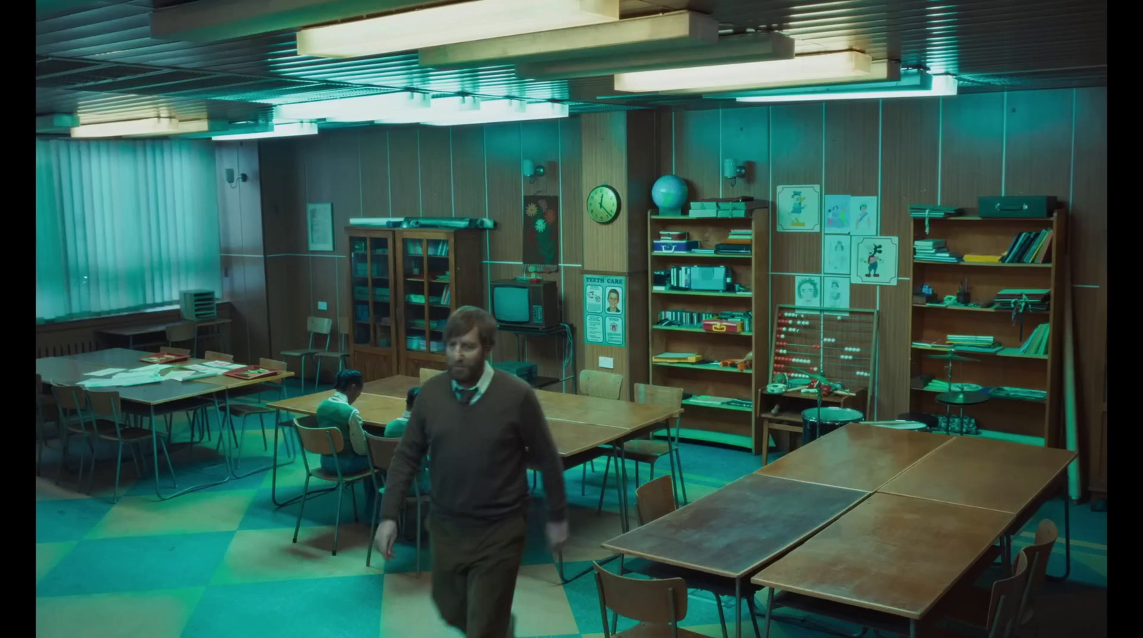 a man walking through a room filled with tables and chairs