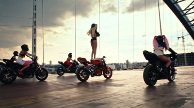 a woman standing on top of a red motorcycle