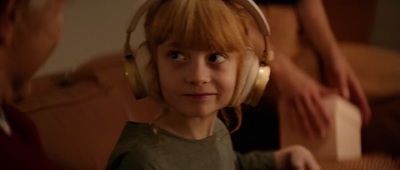 a young boy wearing headphones and looking at the camera