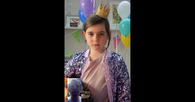 a young girl wearing a crown and holding a stuffed animal