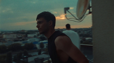 a man standing on top of a roof next to a tall building