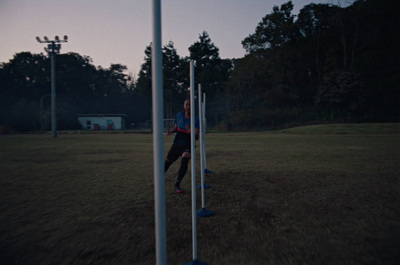 a man standing next to a pole on top of a field