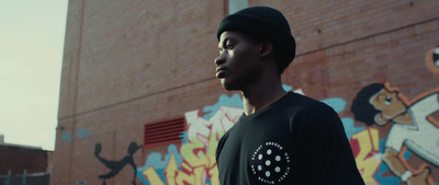 a man standing in front of a building with graffiti on it