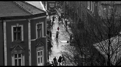 a black and white photo of people walking down a street