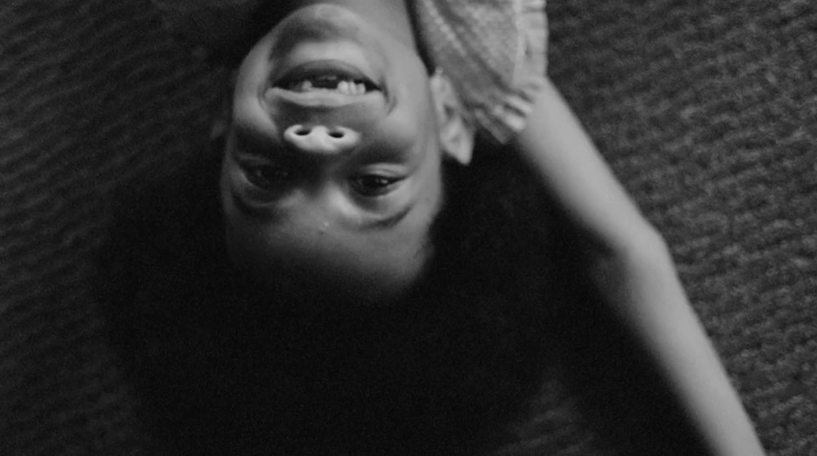 a young child laying on the floor with a fake head