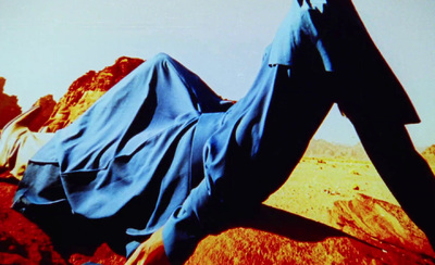 a person laying on a rock in the desert