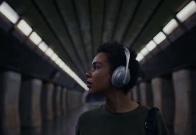 a woman wearing headphones standing in a tunnel