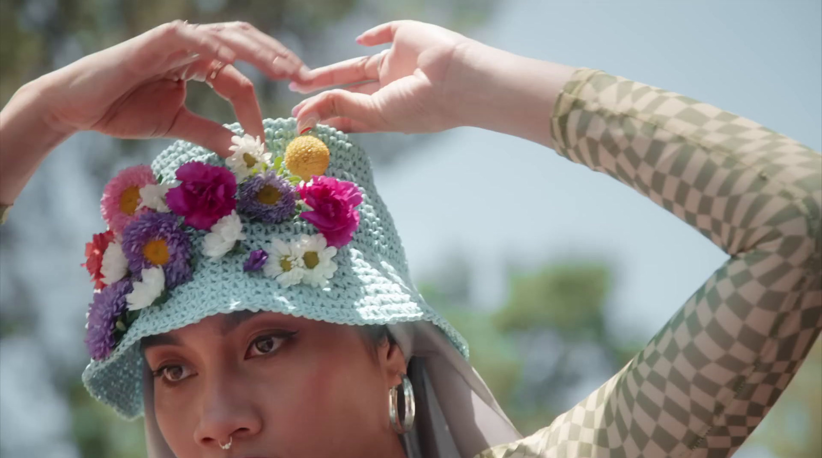 a woman wearing a hat with flowers on it