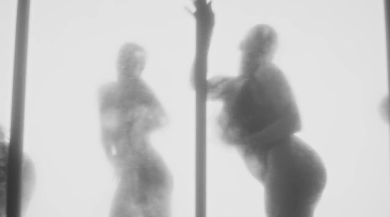 a blurry photo of a woman standing next to a pole