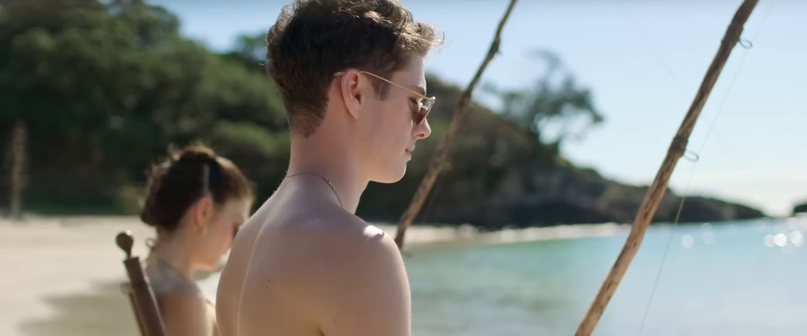 a man and a woman on a beach next to a body of water