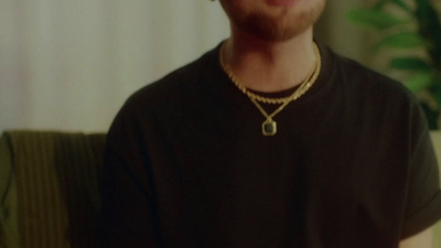 a man wearing a necklace and a black shirt