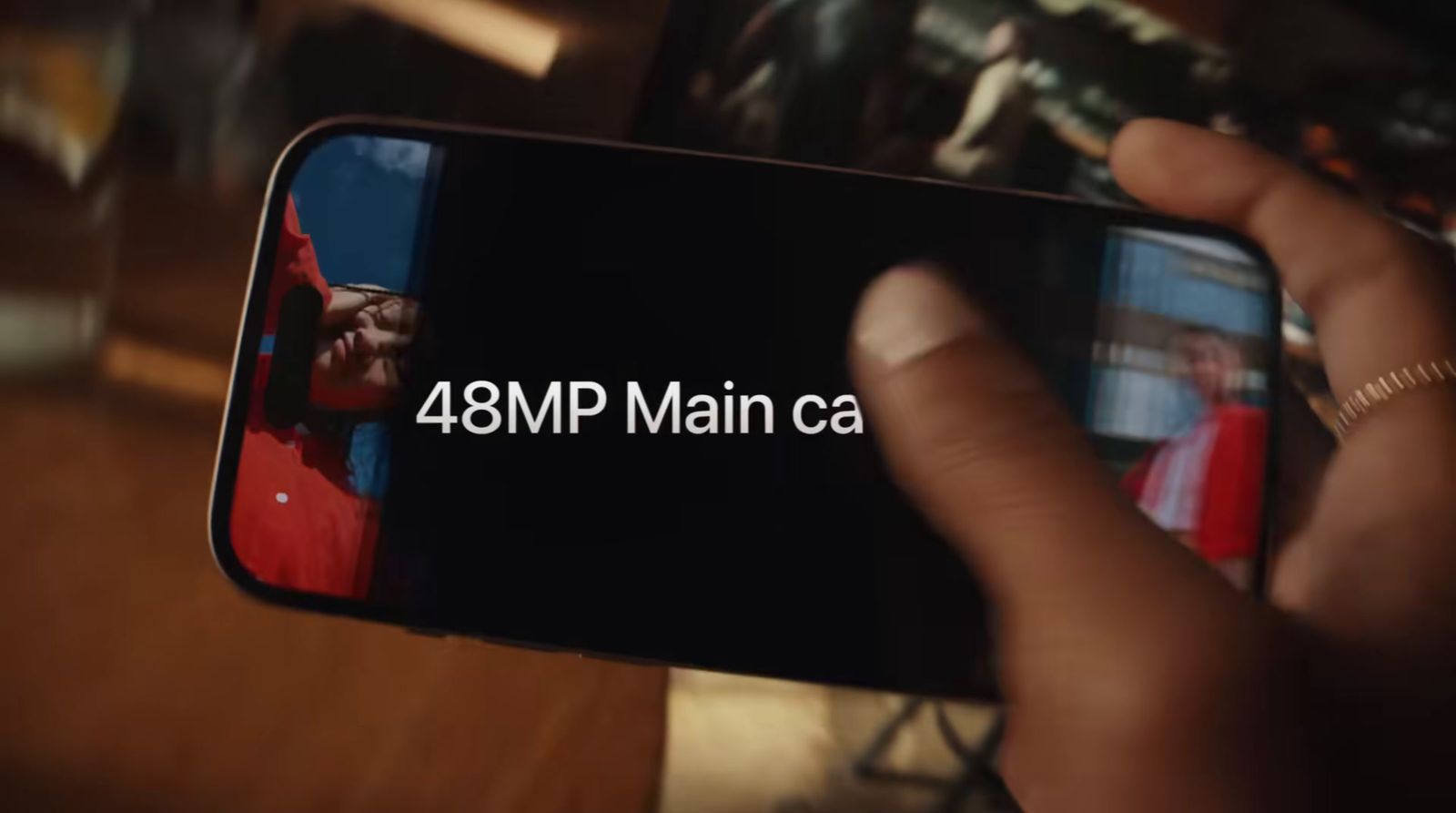 a person holding a cell phone with the text 48mp main ca on it