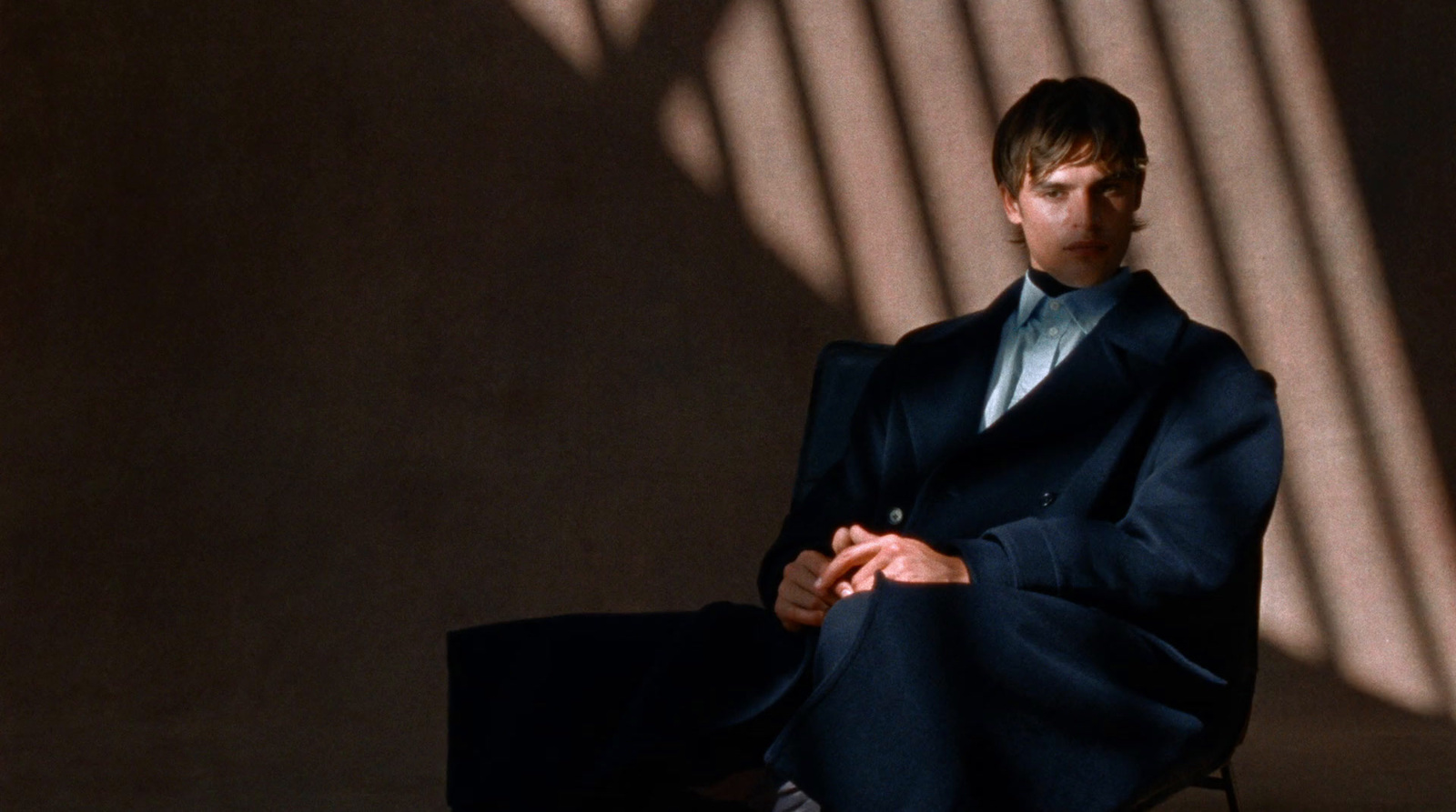 a man in a suit sitting in a chair