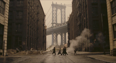 a group of people walking down a street next to tall buildings