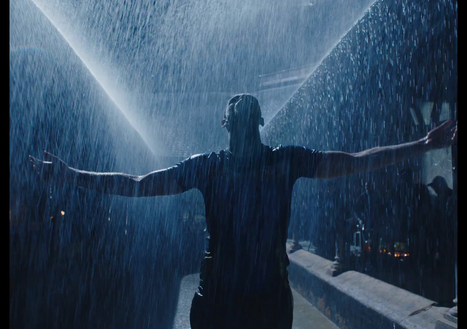 a man standing in the rain with his arms outstretched