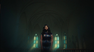 a woman standing in front of a window in a dark room