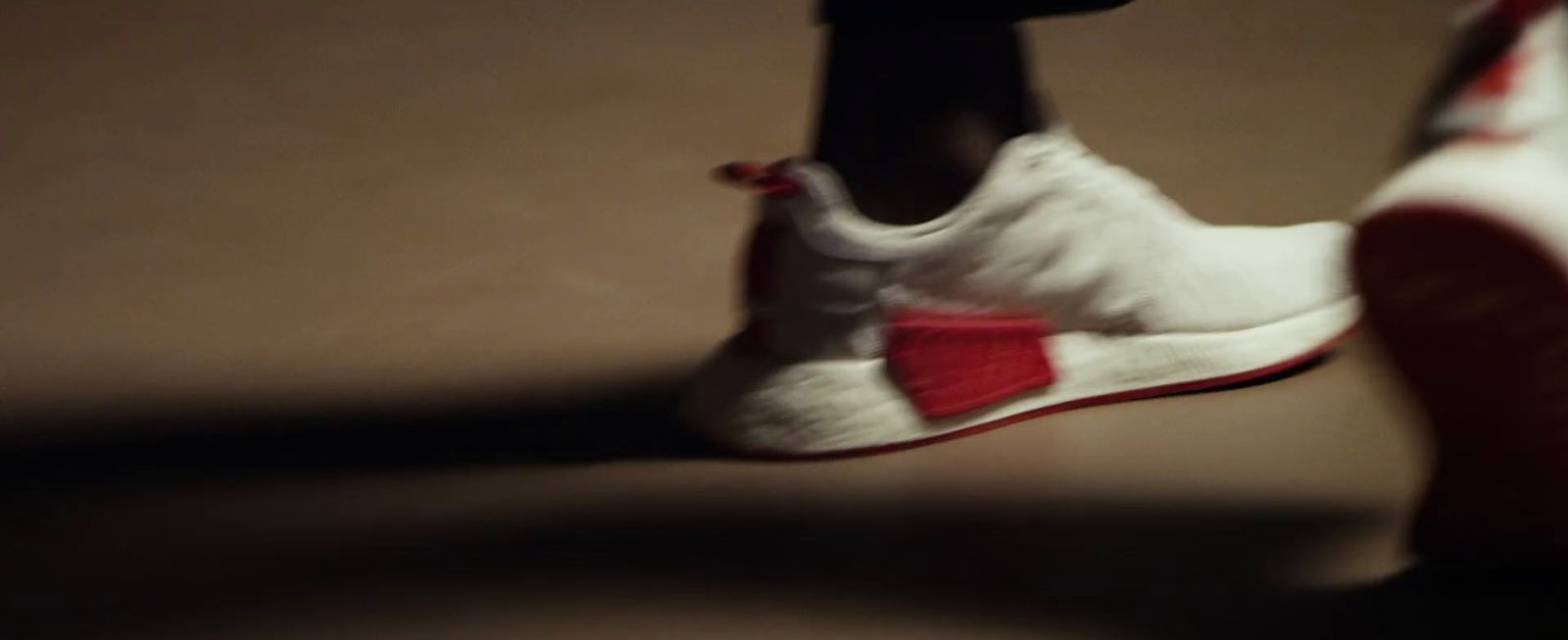 a close up of a person's white and red sneakers