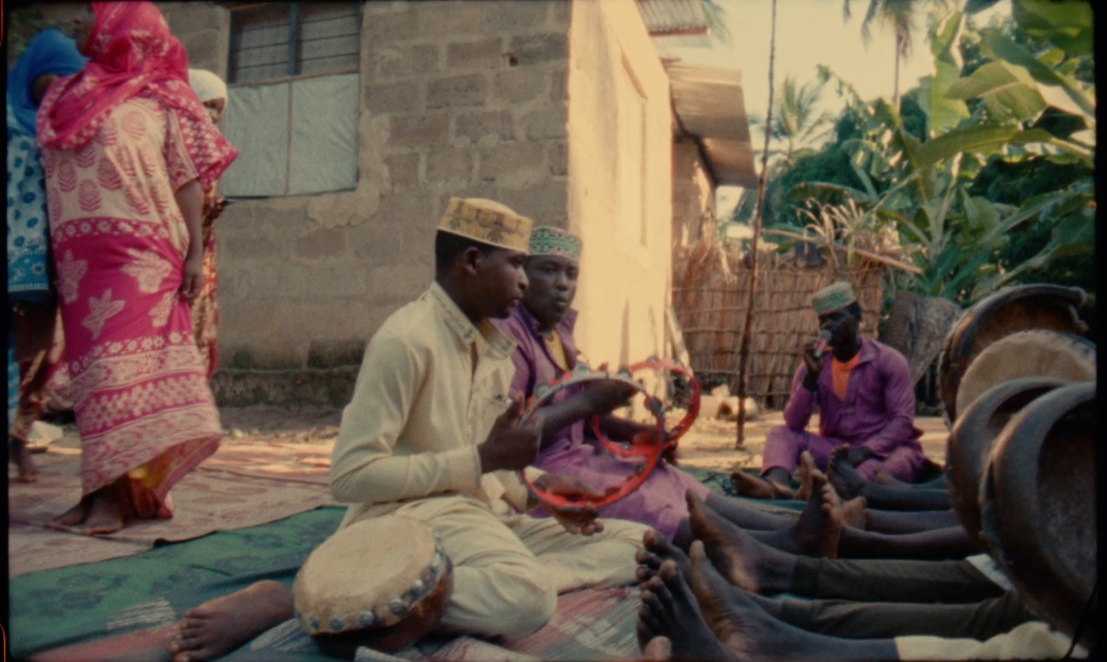 a group of men sitting on the ground next to each other