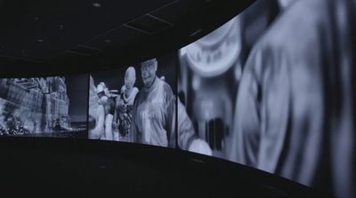 a group of people standing in front of a large screen