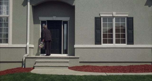 a man standing on the steps of a house