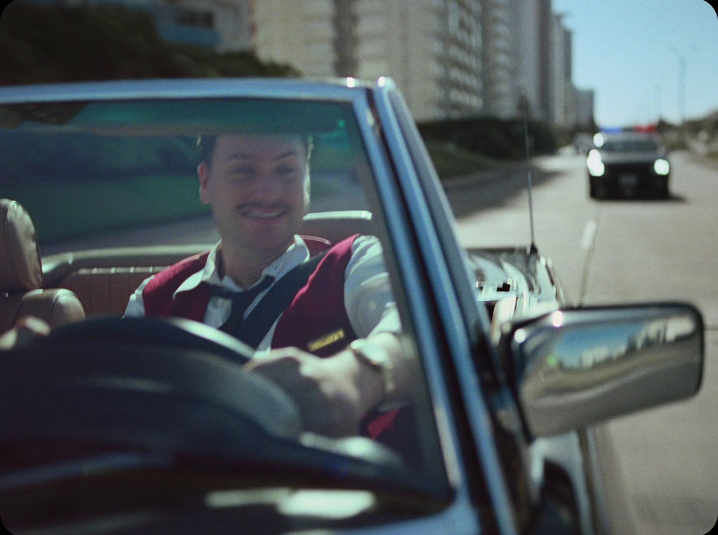 a man driving a car on a city street