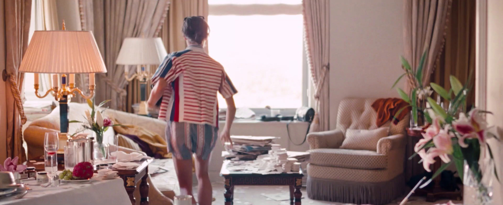 a woman standing in a living room next to a window