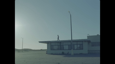 a man standing on top of a building next to a street light