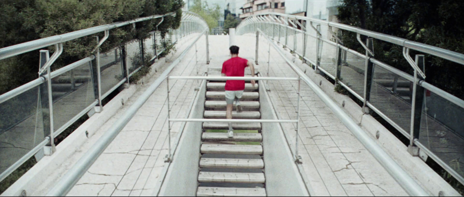 a man in a red shirt is walking down some stairs