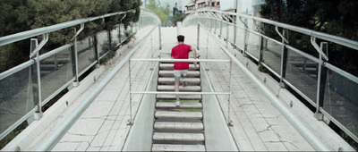 a man in a red shirt is walking down some stairs