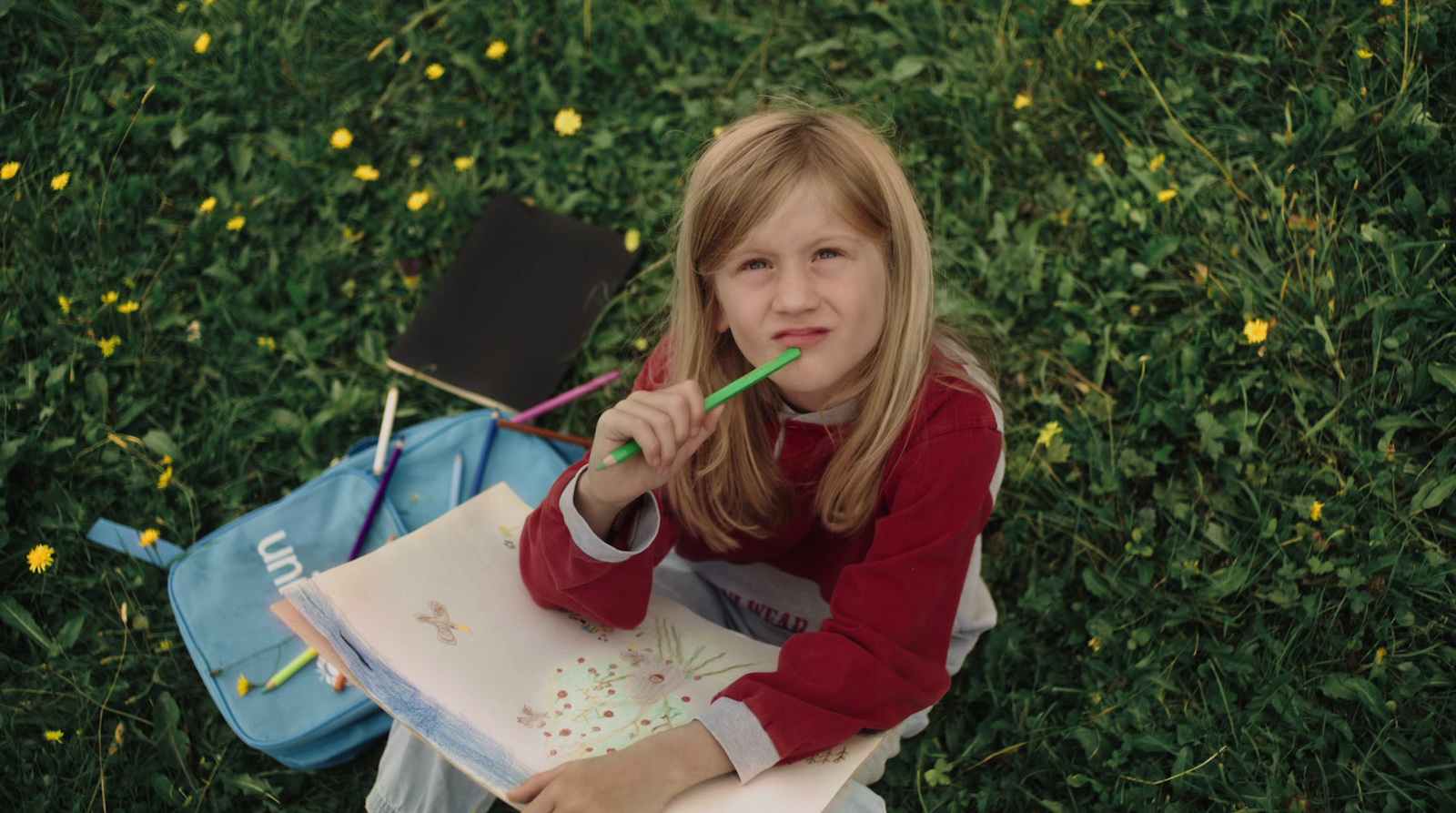 a little girl sitting on the ground with a book and a toothbrush in her