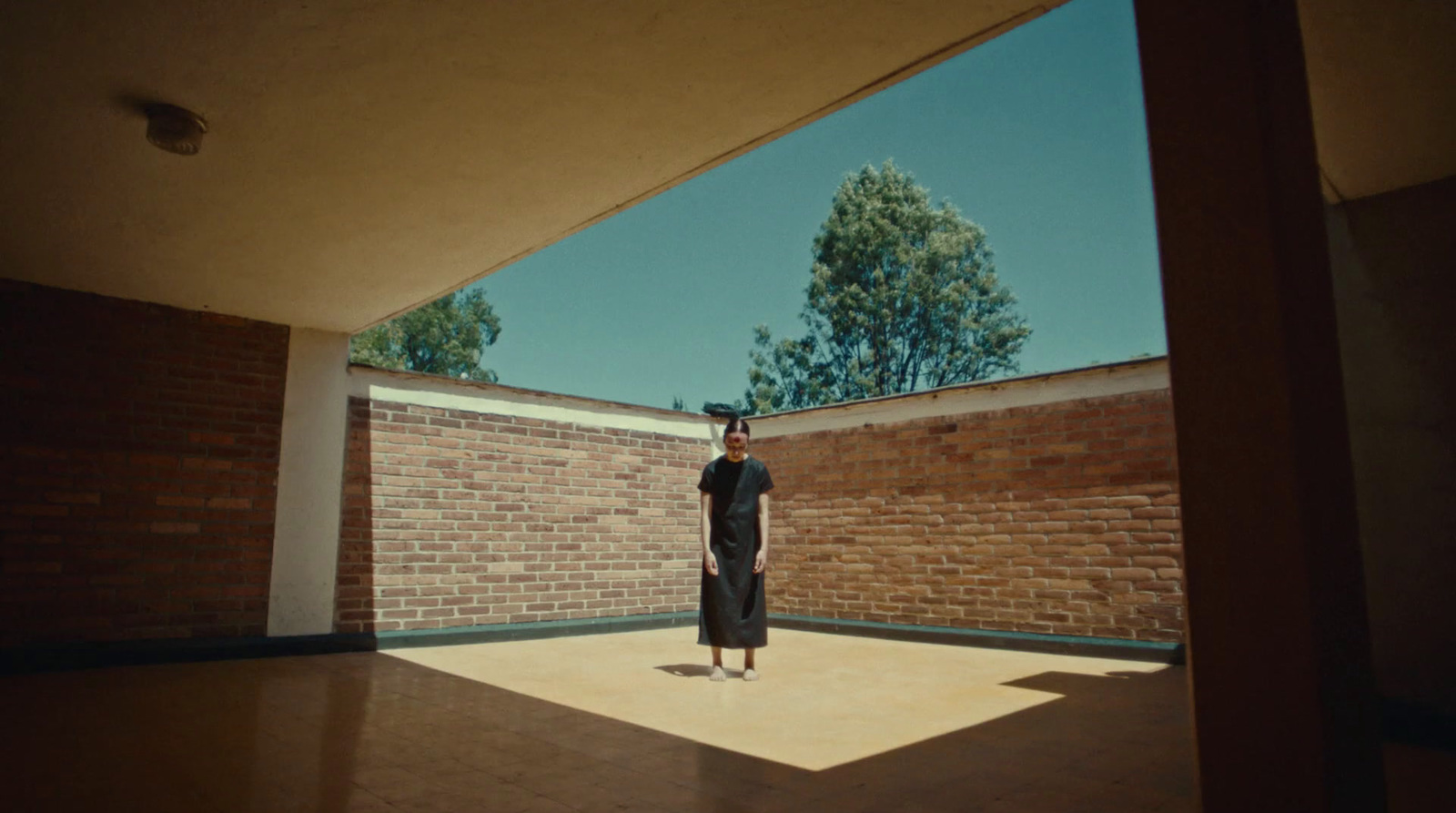 a person standing in a room with a brick wall