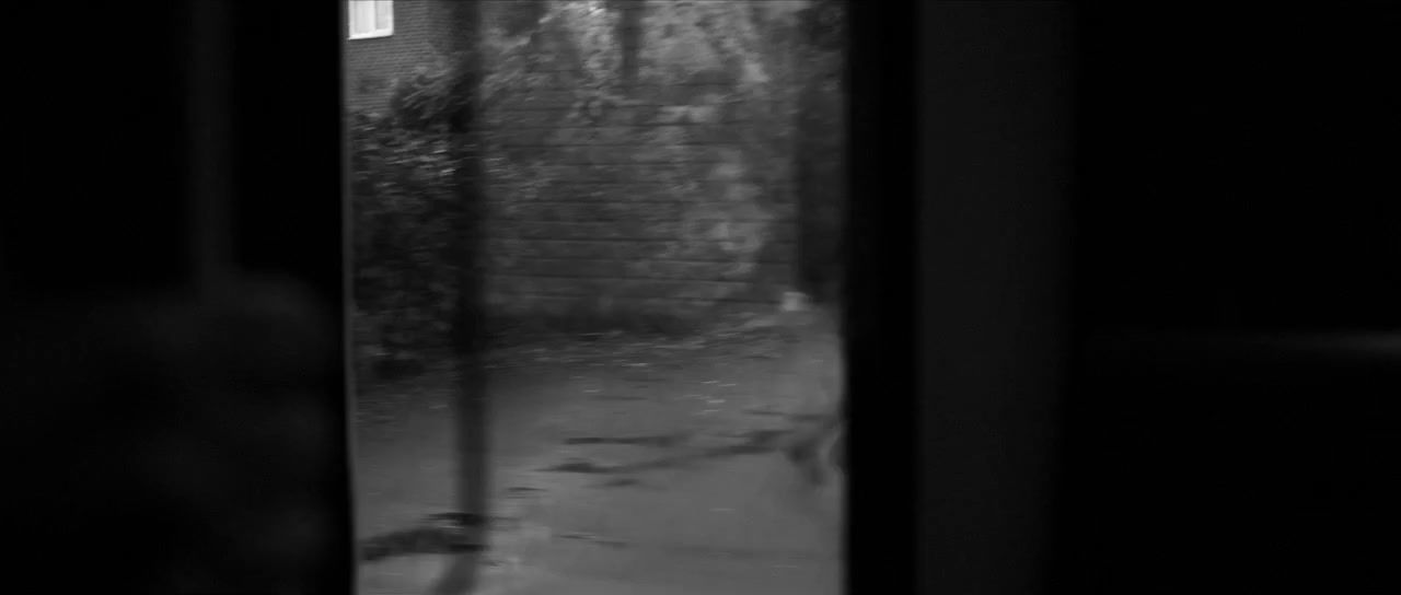 a black and white photo of a person looking out a window