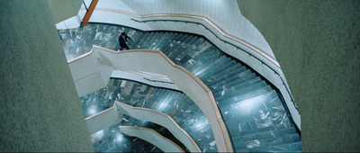 a man walking down a spiral staircase in a building