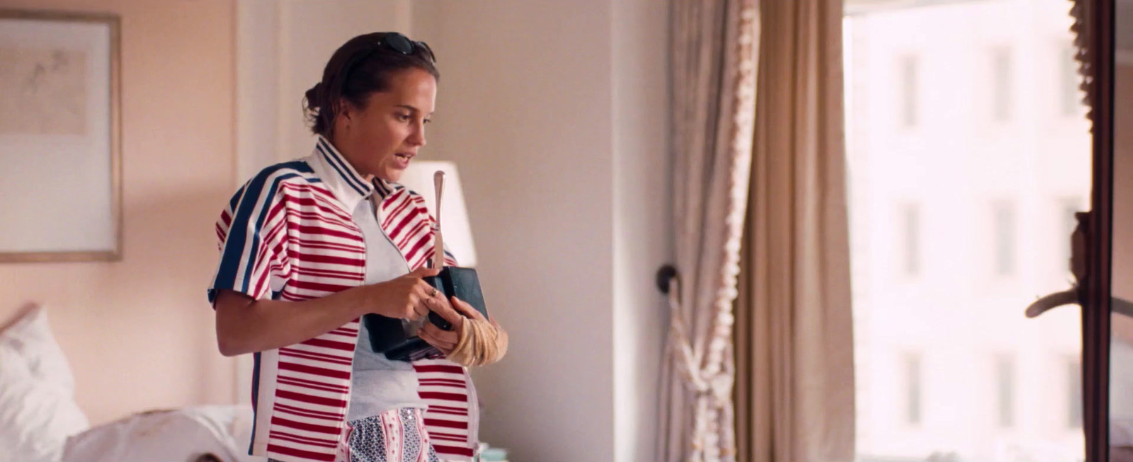 a woman in a red and white striped shirt holding a baseball bat