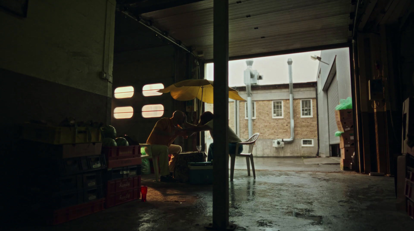 a person sitting on a chair under an umbrella