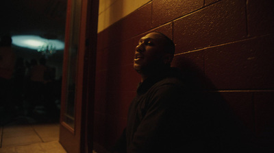 a man standing next to a brick wall