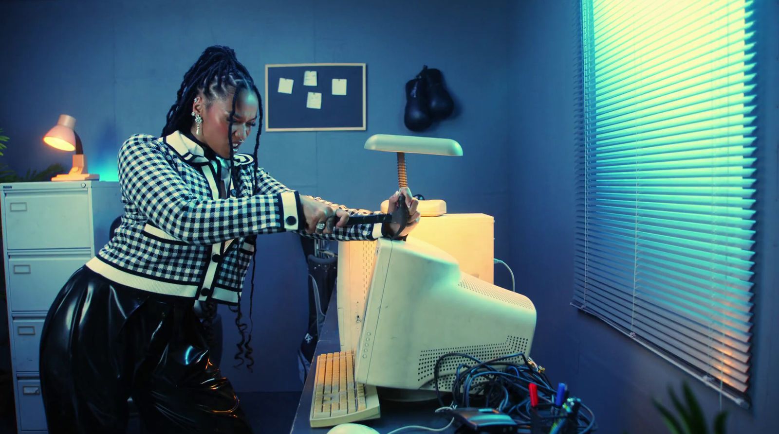 a woman in a black and white checkered shirt working on a computer