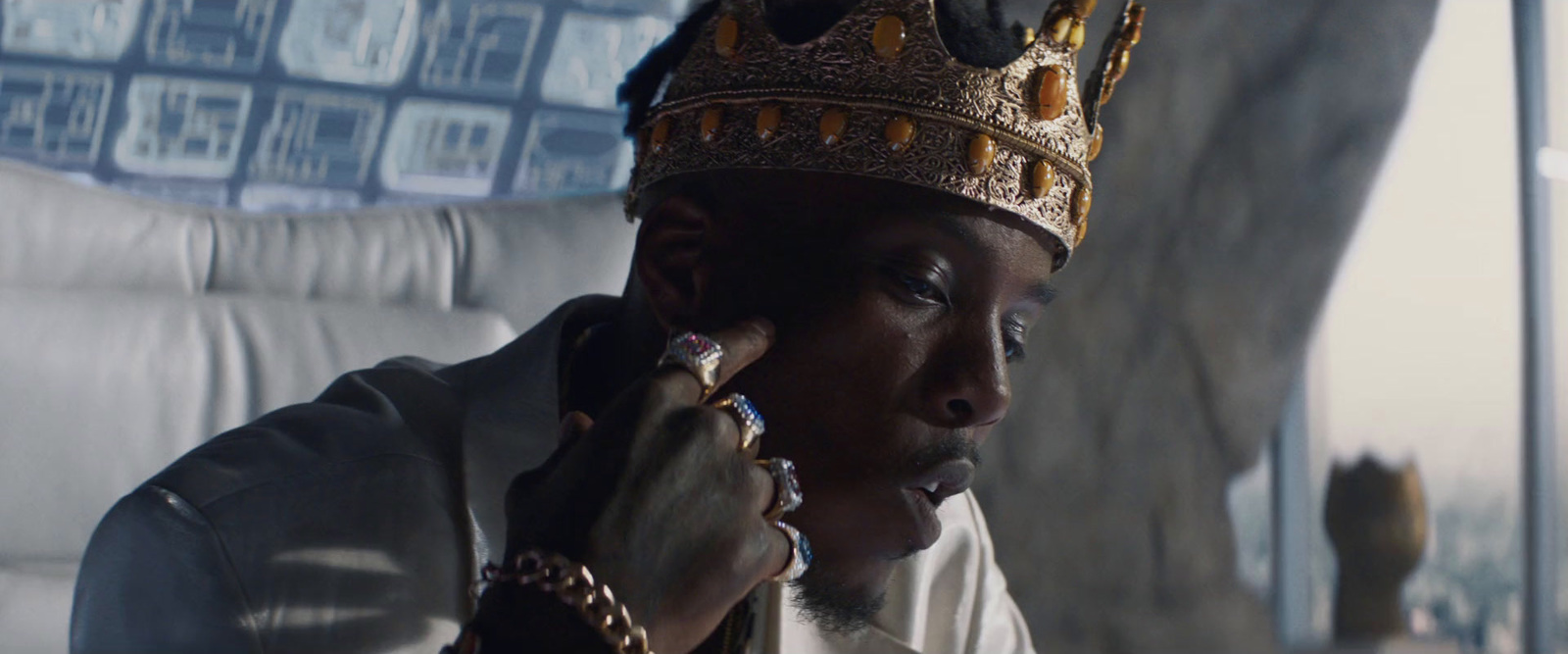 a man wearing a crown sitting on a couch