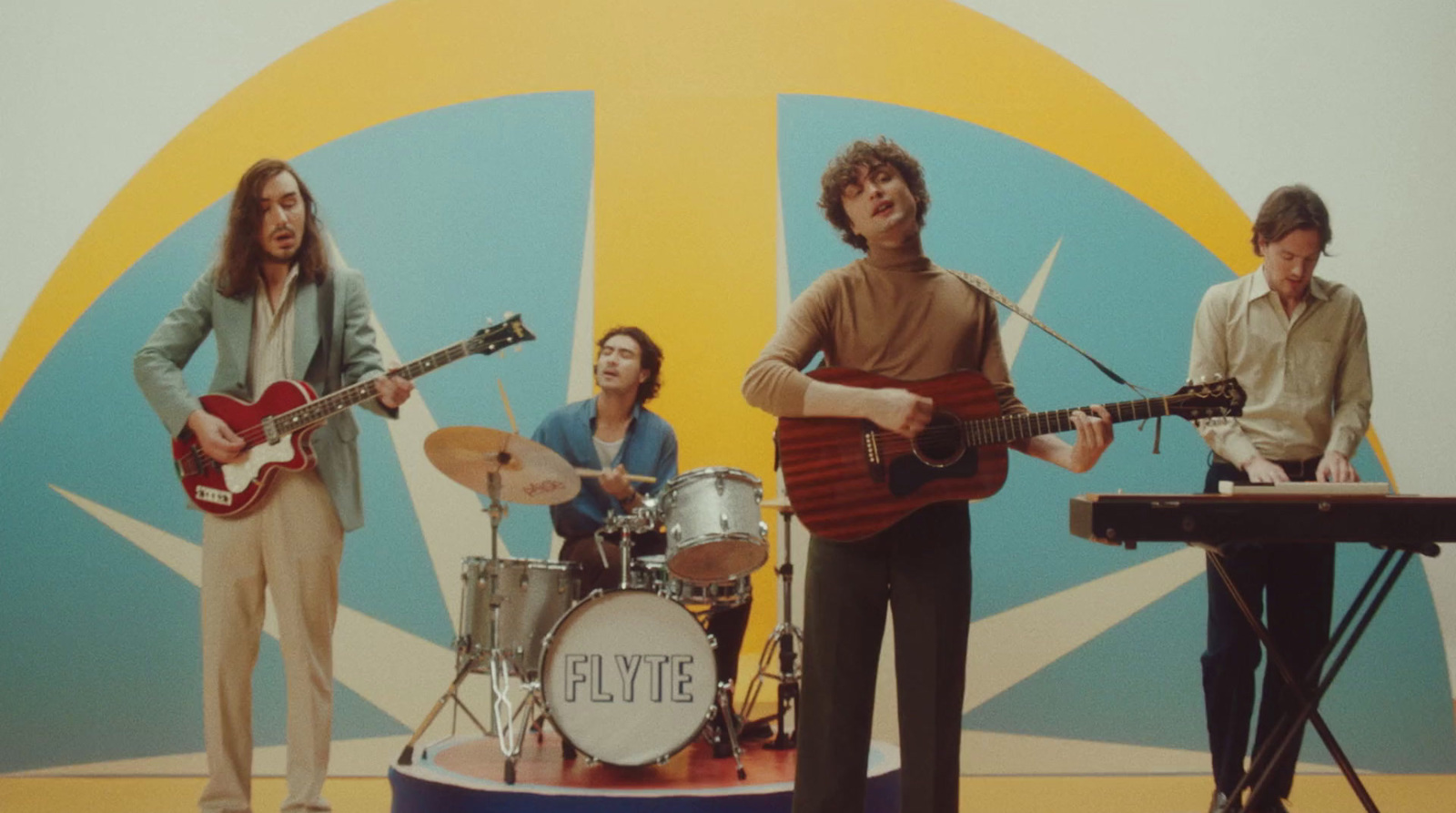 a group of people standing around a drum set