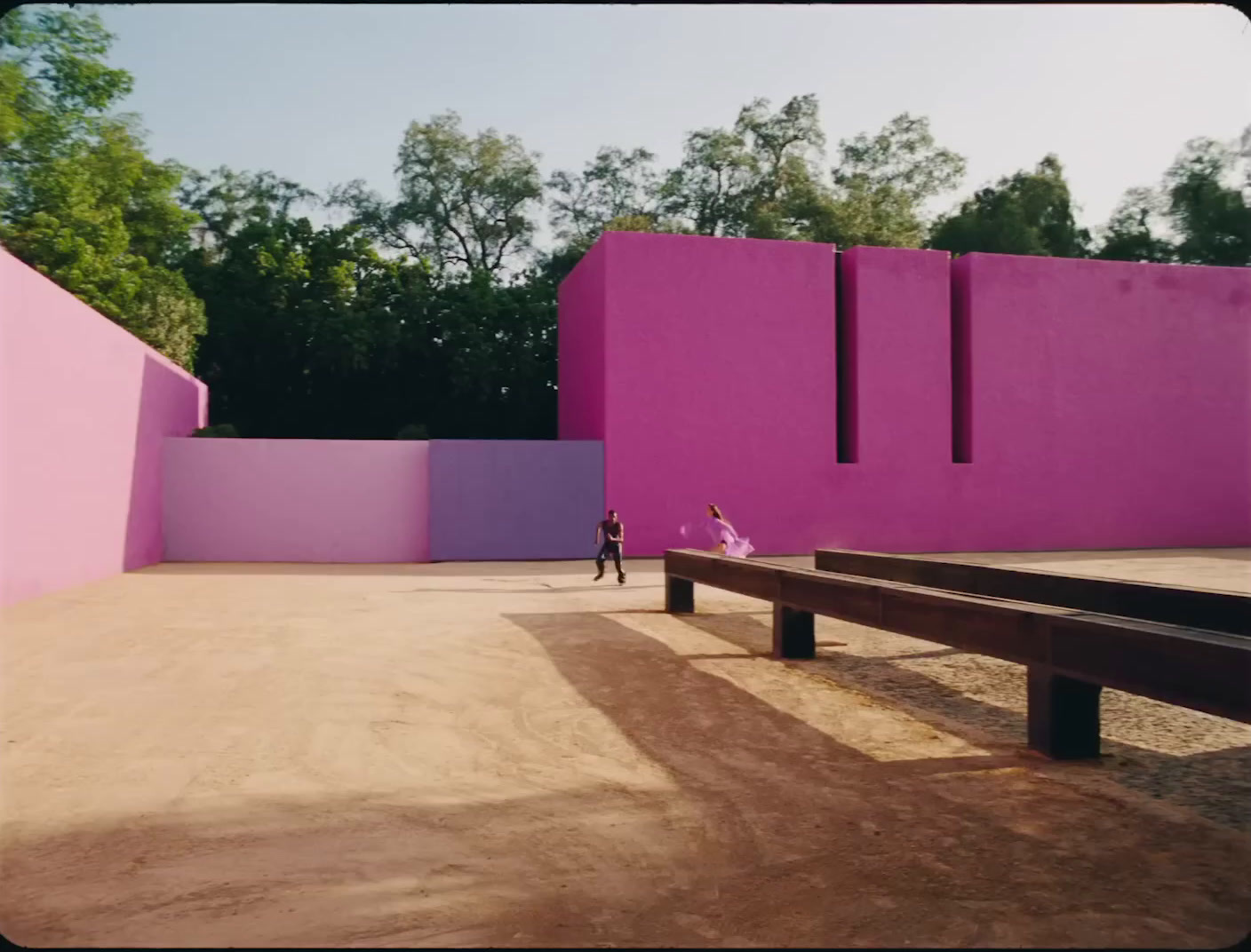 a person standing in front of a pink building