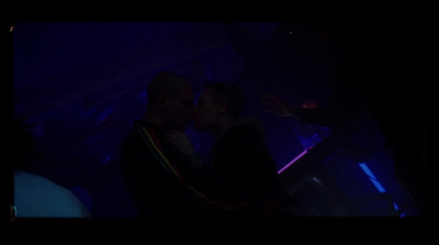 a man and a woman kissing in a dark room