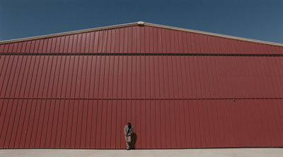 a person standing in front of a red building