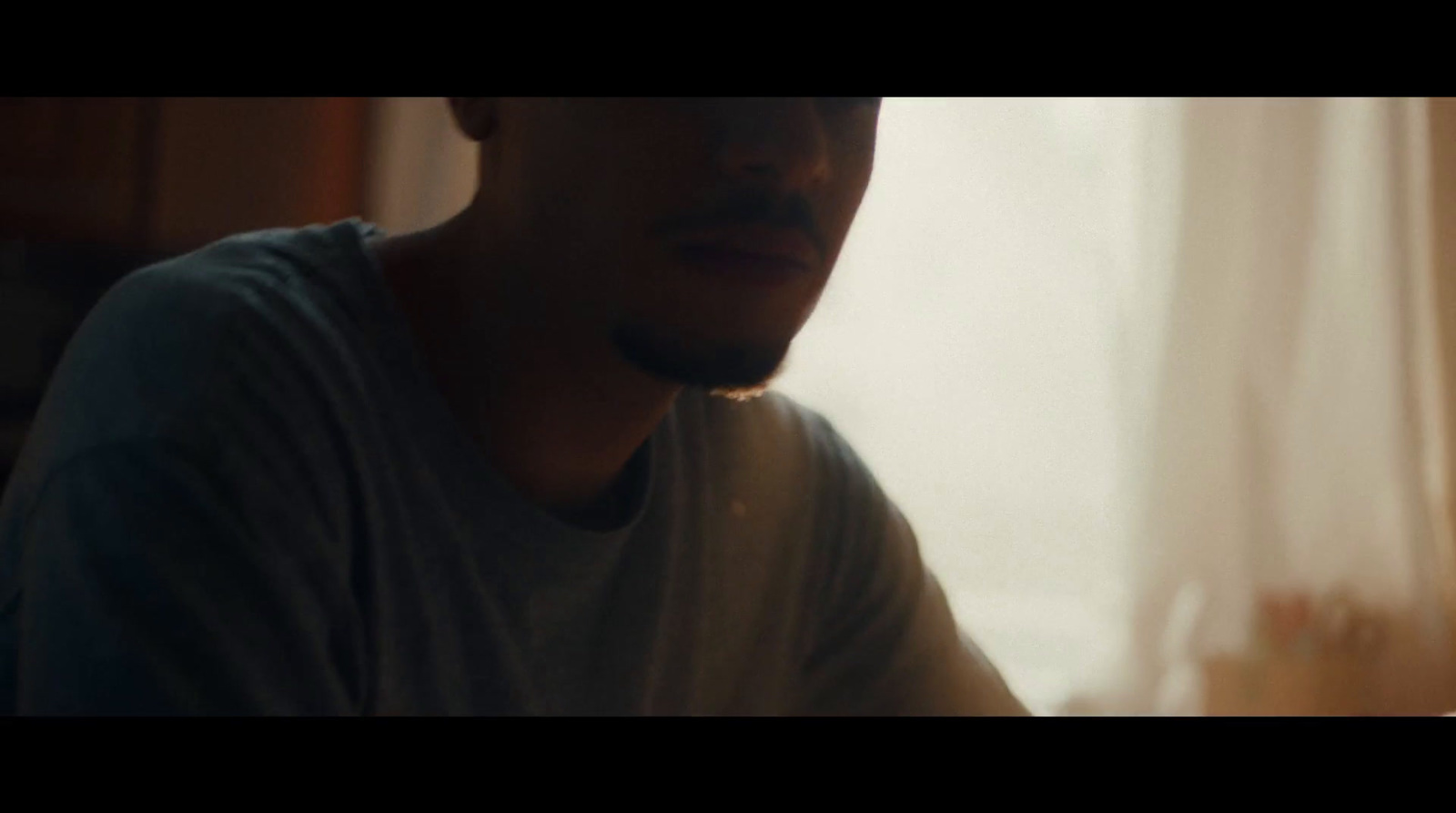 a man sitting in front of a window next to a window