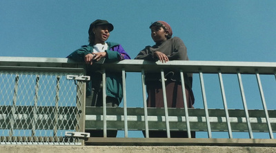 a couple of people standing on top of a bridge