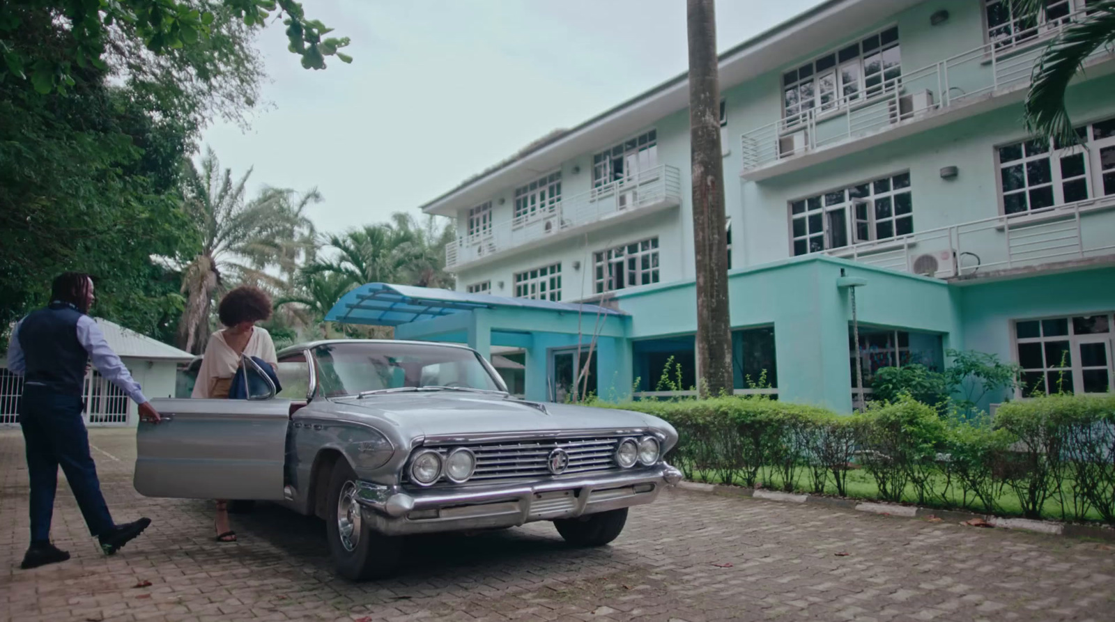 a man and a woman standing next to a car