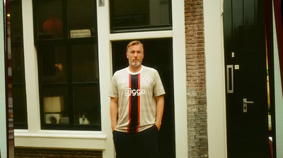 a man standing in front of a door wearing a shirt and tie